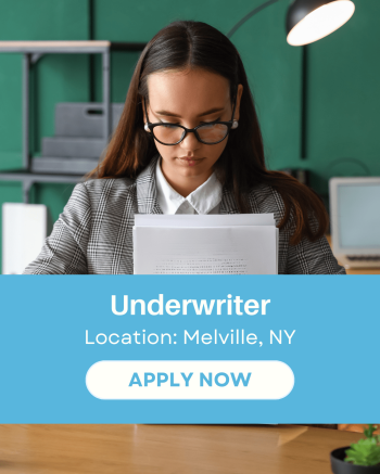 Mortgage underwriter reviewing documents at a desk with a laptop